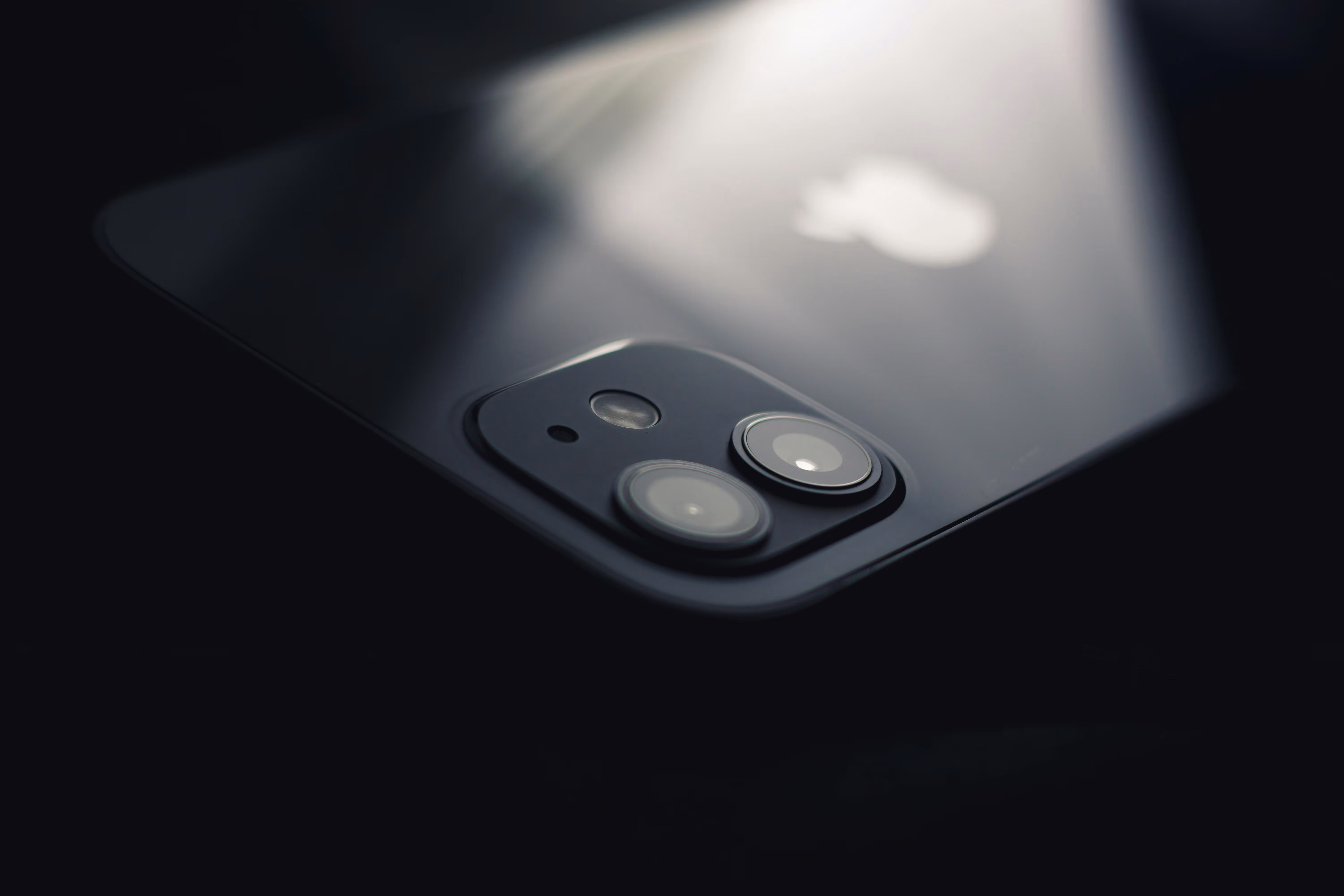 Close-up of the dual camera lenses on the back of a black Apple iPhone.