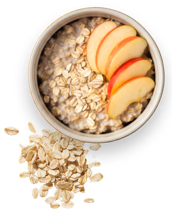 Bowl of oatmeal topped with rolled oats and sliced apple pieces, with additional rolled oats beside the bowl.
