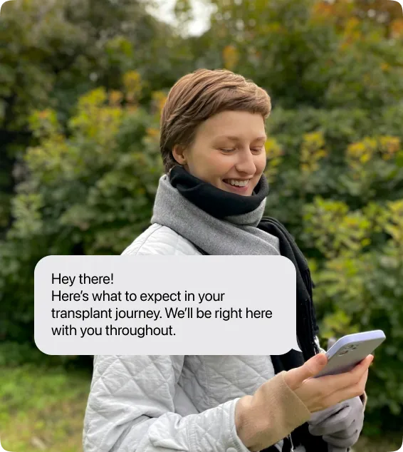A patient smiling at a text from Stitch: Here's what to expect in your transplant journey