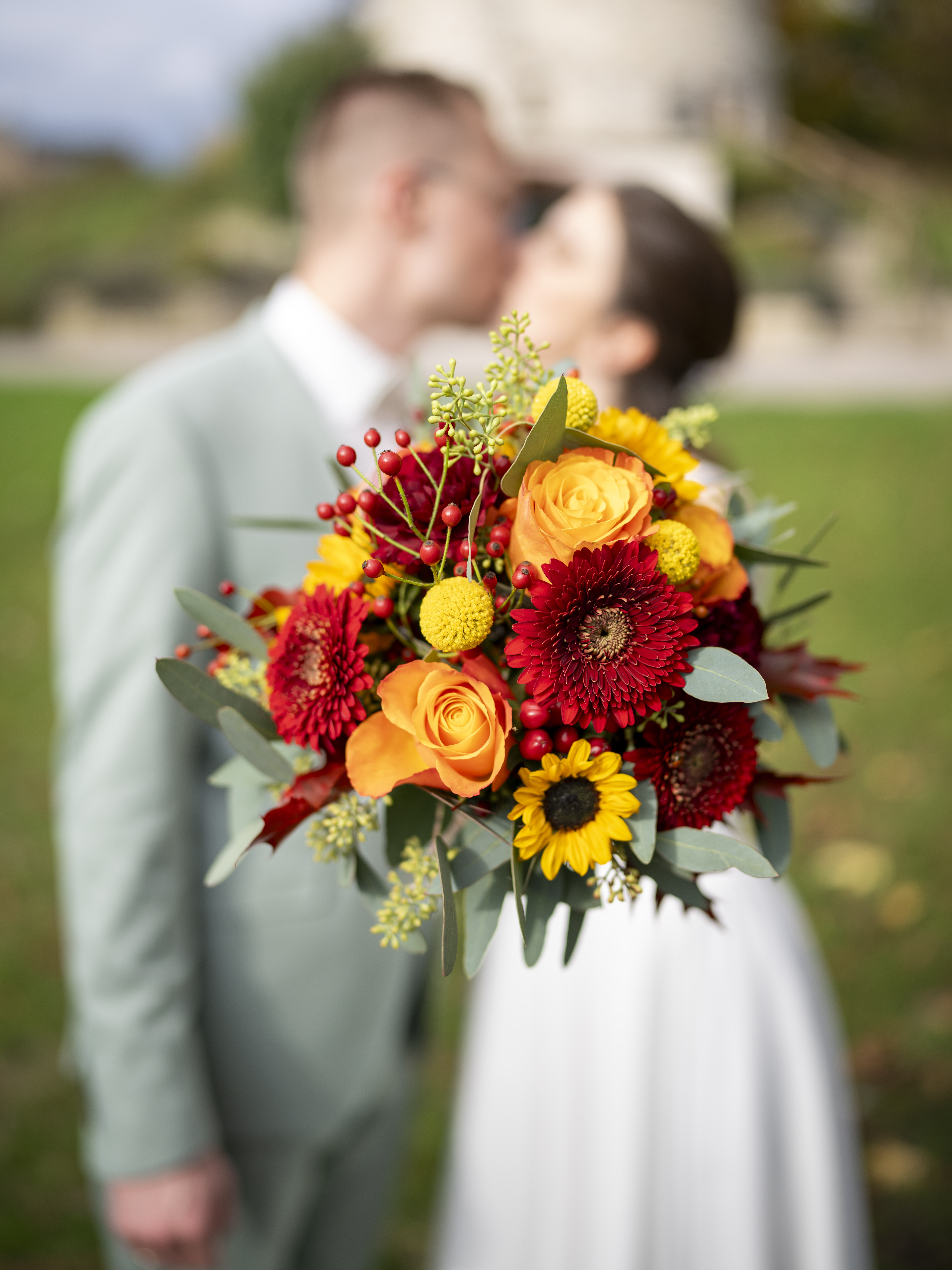 Foto von dem Brautstrauß, Brautpaar im Hintergrund