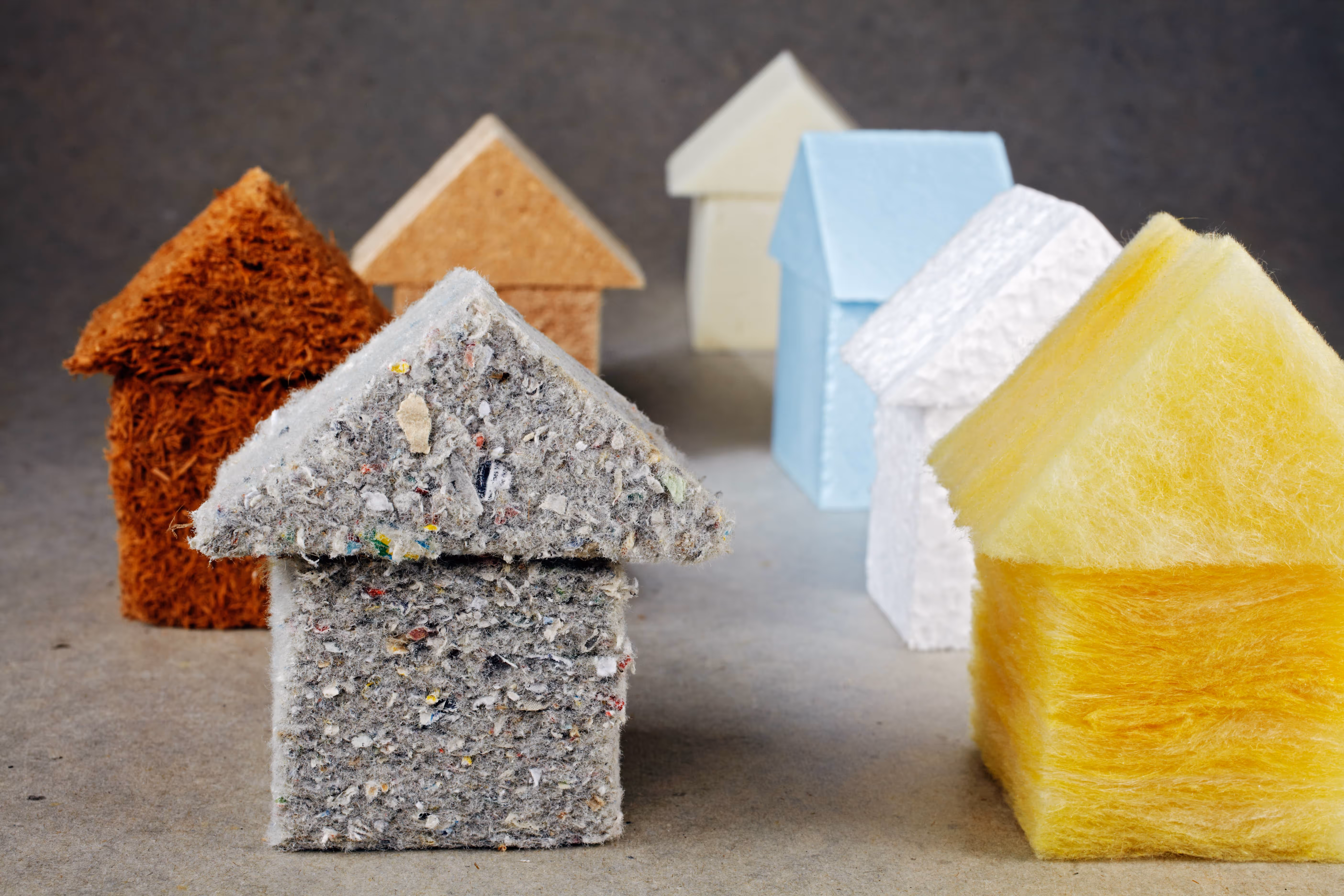 verschiedene Dämmstoffe in Form kleiner Häuser