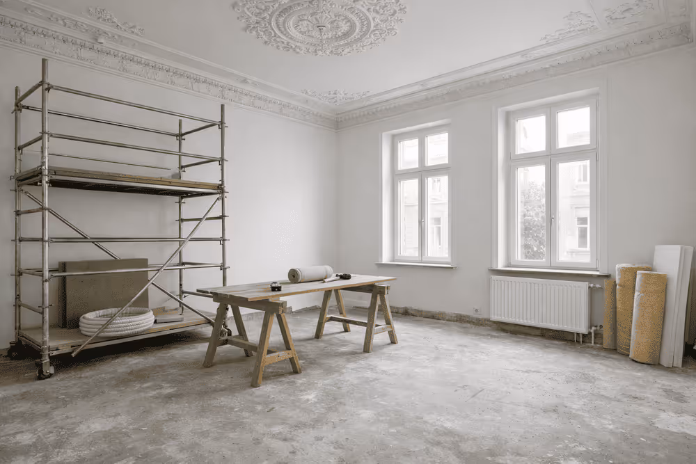  Altgebäude während einer energetischen Sanierung, mit hohen Decken, Stuckverzierungen, großen Fenstern, Gerüst und Fokus auf energieeffiziente Renovierung.