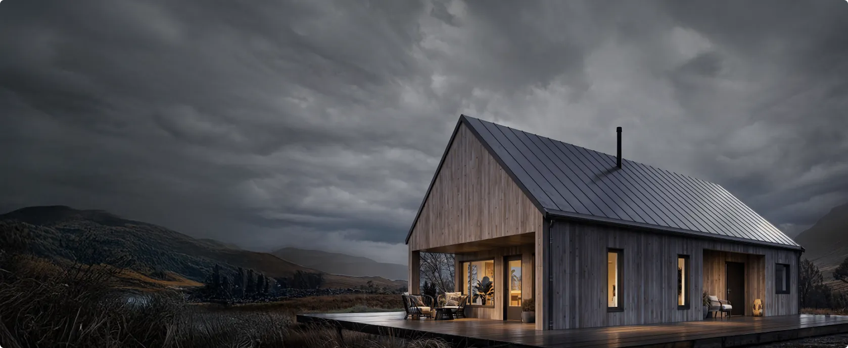 Modern wooden house with illuminated windows on a deck, set against a moody cloudy sky and mountainous landscape at dusk.