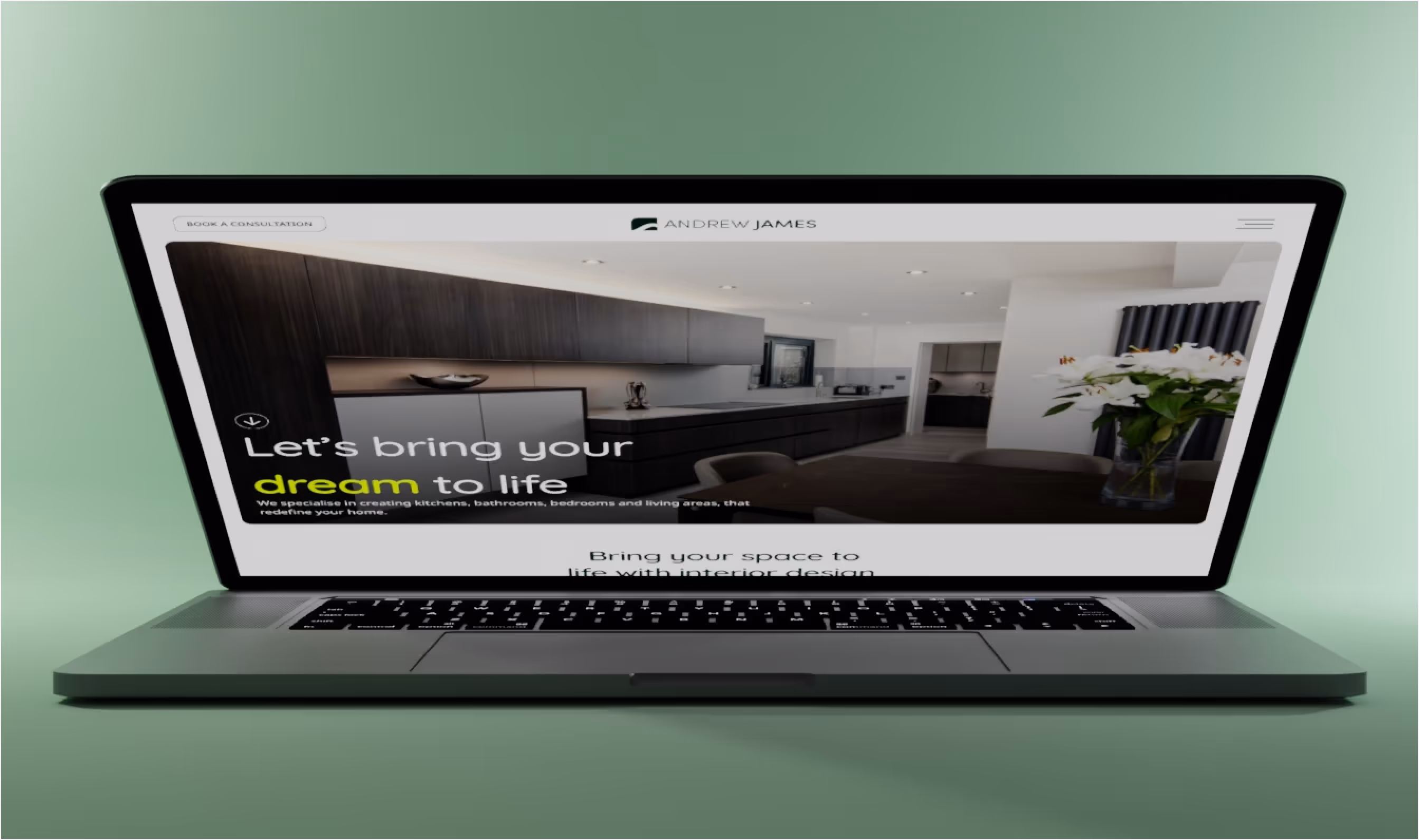 Laptop displaying Andrew James home page with modern kitchen.