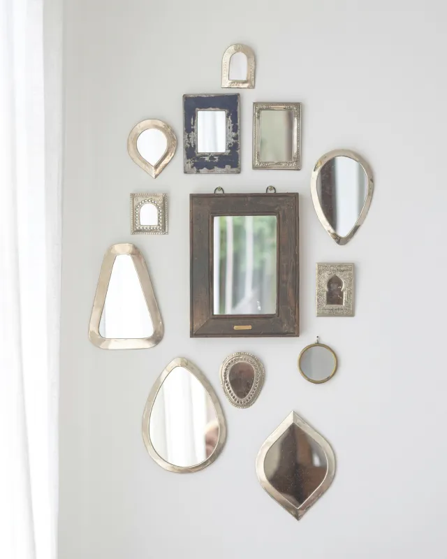 Mirrors of all shapes and sizes on wall