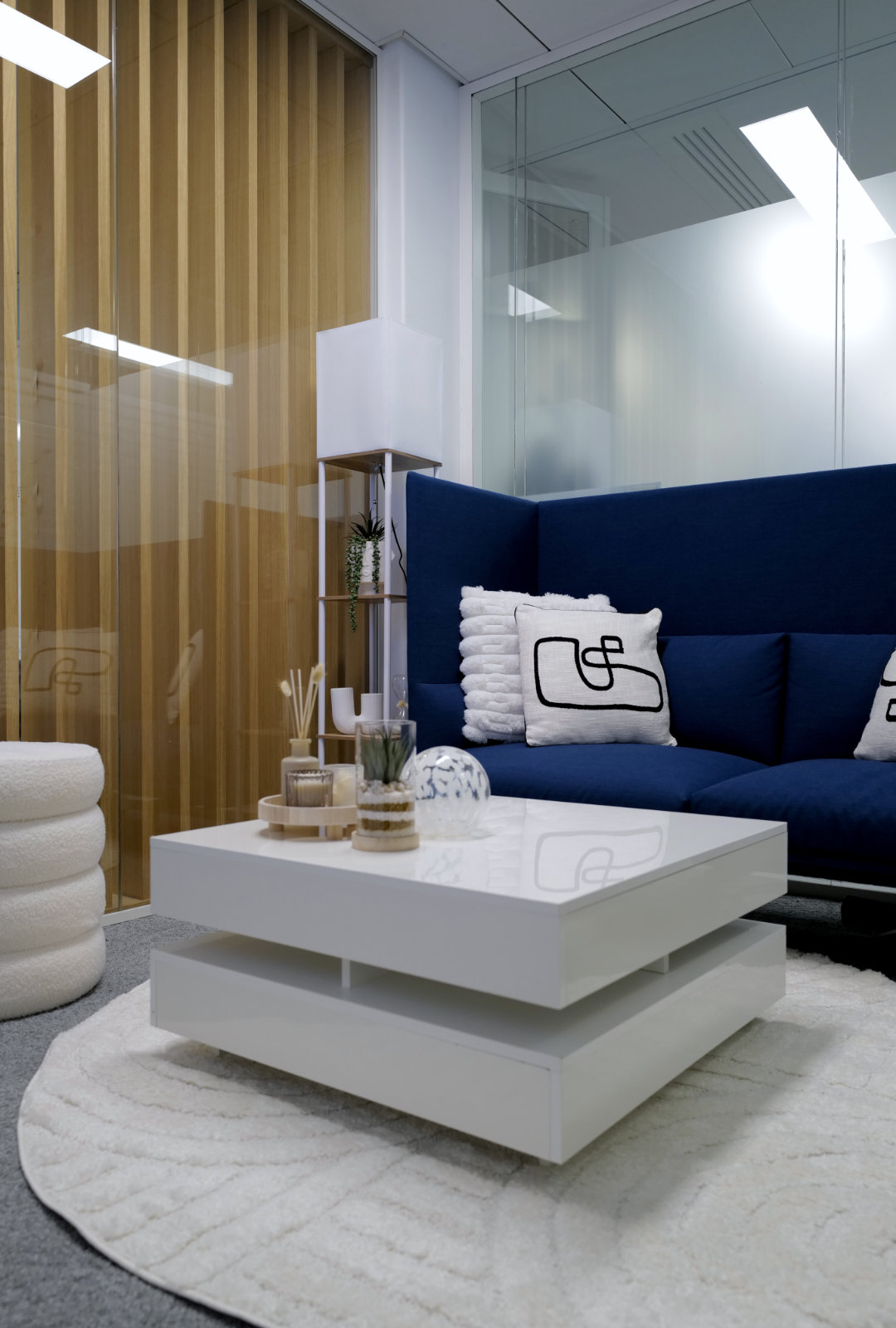 Espace lounge moderne du Studio TV Vendôme Saint-Honoré à Paris, avec canapé bleu et table basse design.