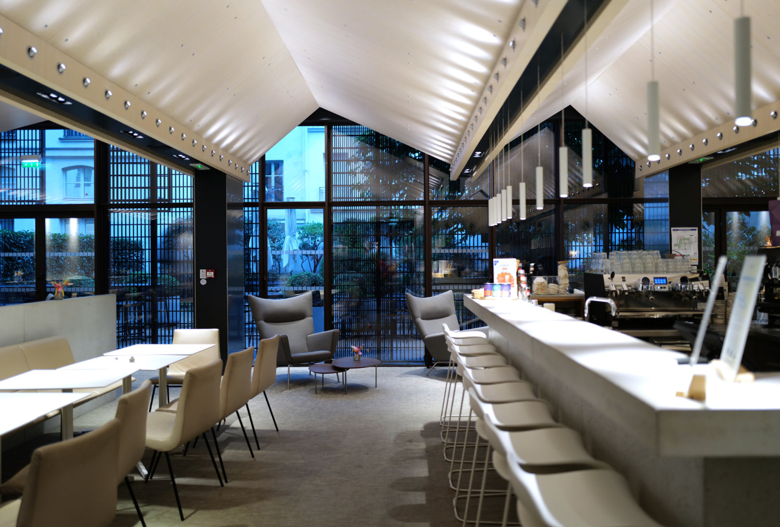 Espace café lounge du Studio Vendôme Saint-Honoré à Paris, avec bar design et grandes baies vitrées.