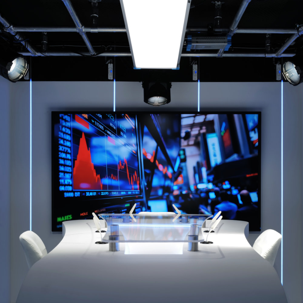 'Studio Vendôme Saint-Honoré'  a curved white table, white chairs, and a large screen displaying a financial stock market chart.