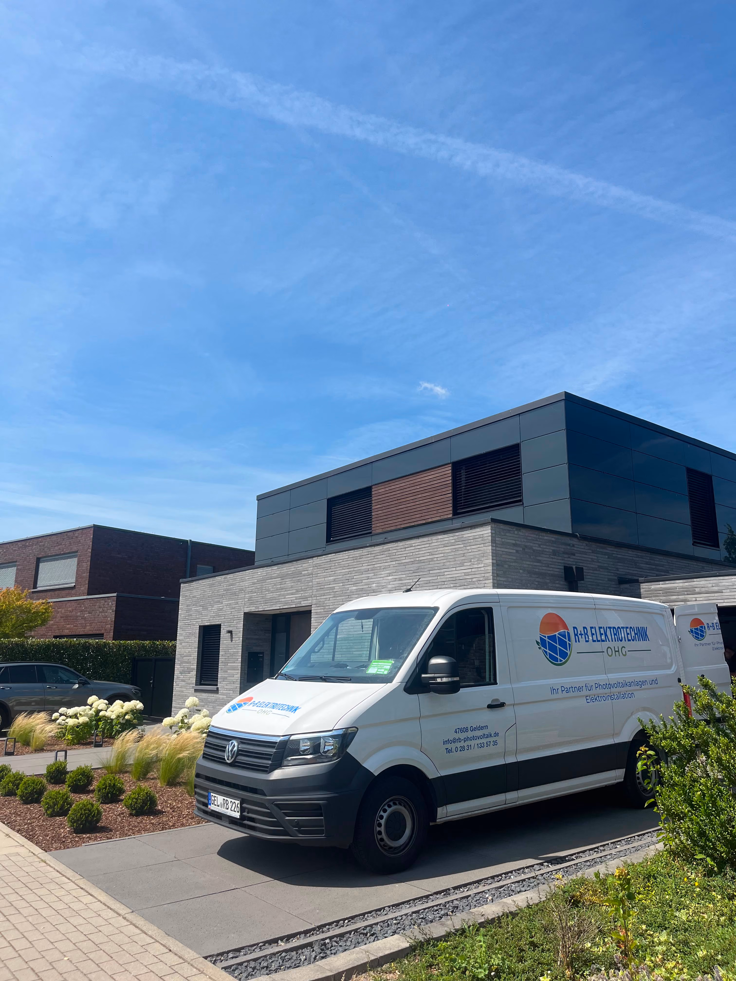 Firmenwagen der R+B Elektrotechnik OHG vor einem modernen Einfamilienhaus am Niederrhein