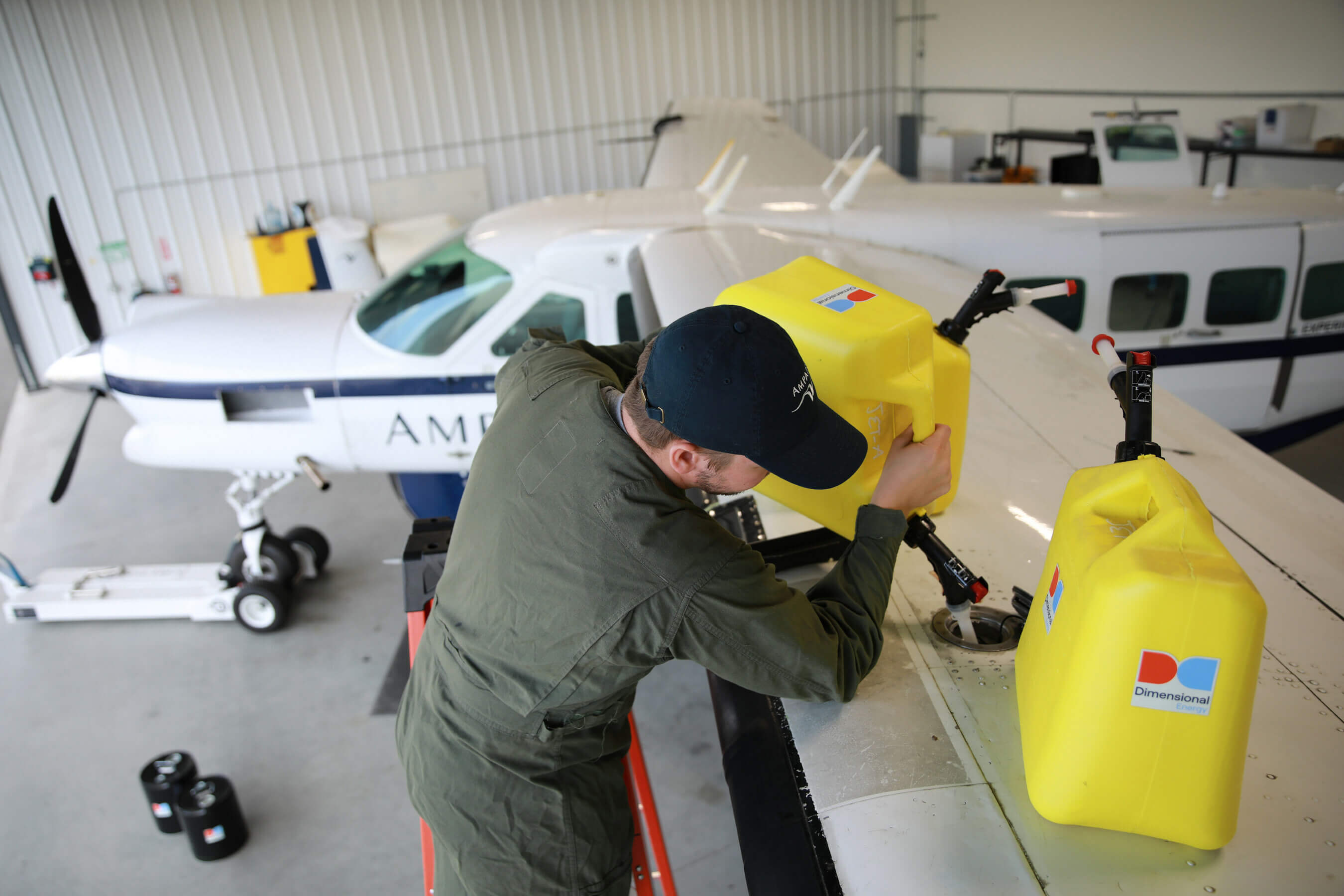 A man refuels a plane with Dimensional Energy Sustainable Aviation Fuel.
