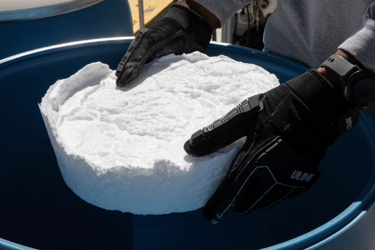Gloved hands holding a large wafer of Dimensional Energy wax.