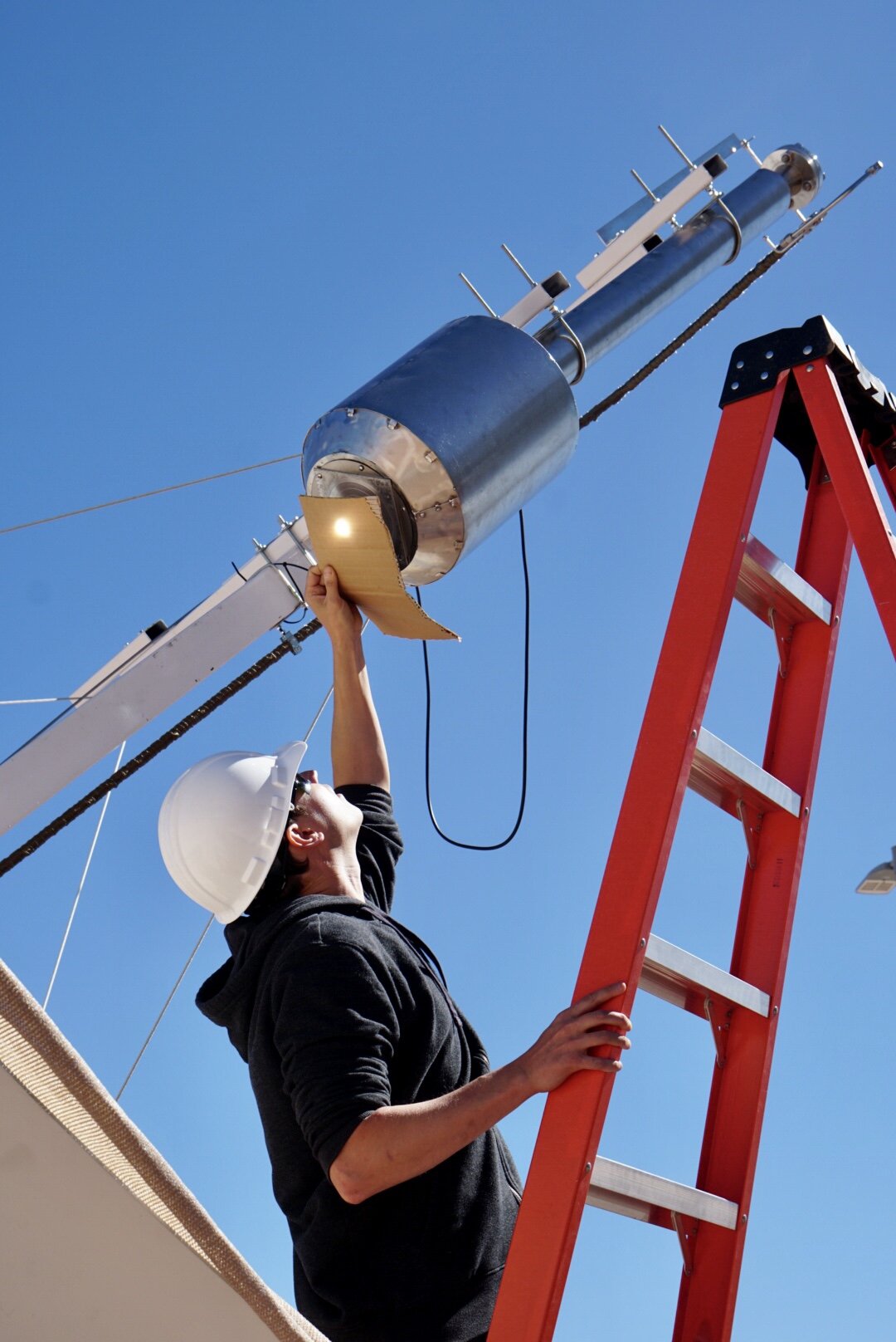 Brad finds the focal point of the parabolic mirror—a combination of serious math and cardboard craftiness.