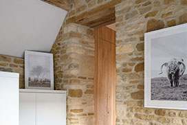 The Cowshed interior with Cotswold stone wall