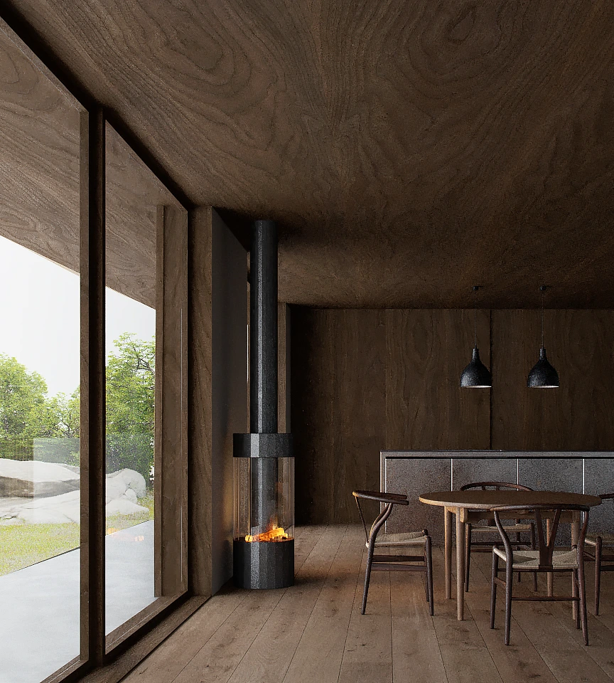 Modern dining area with wooden floor, round wooden table with four chairs, two pendant lights, and a cylindrical black fireplace near large glass windows showing greenery outside.