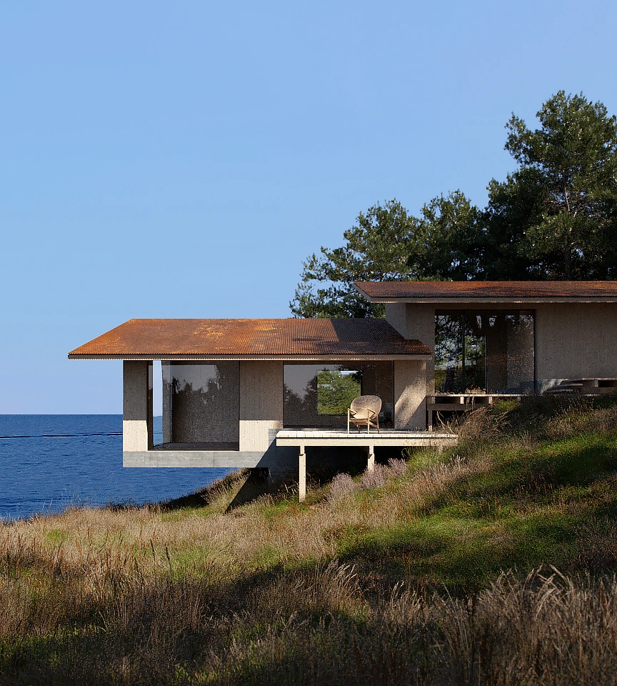 Modern house with rust-colored roof perched on a grassy hillside overlooking a calm blue ocean under a clear sky.