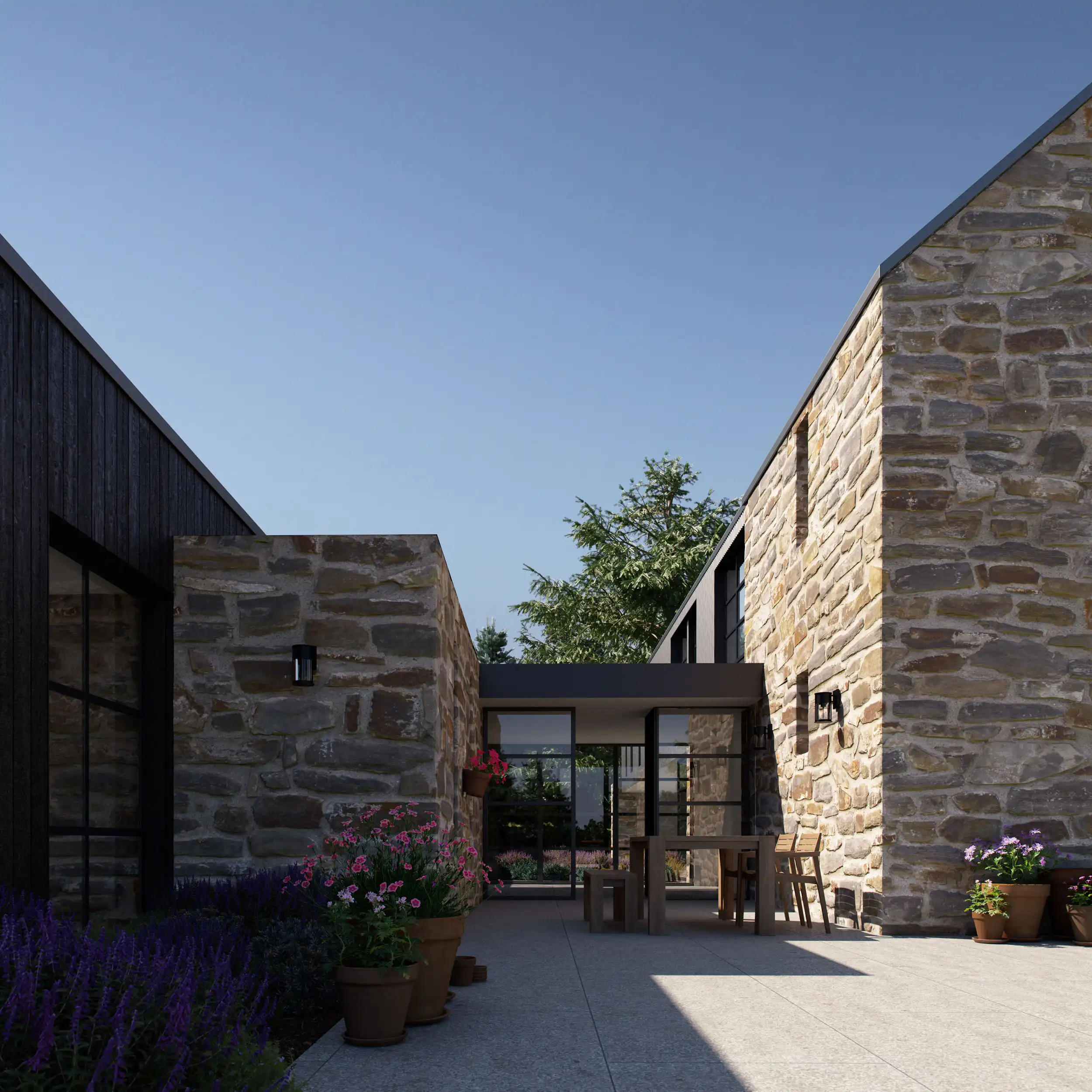 Modern courtyard with stone walls, potted flowers, and wooden outdoor furniture under clear blue sky.