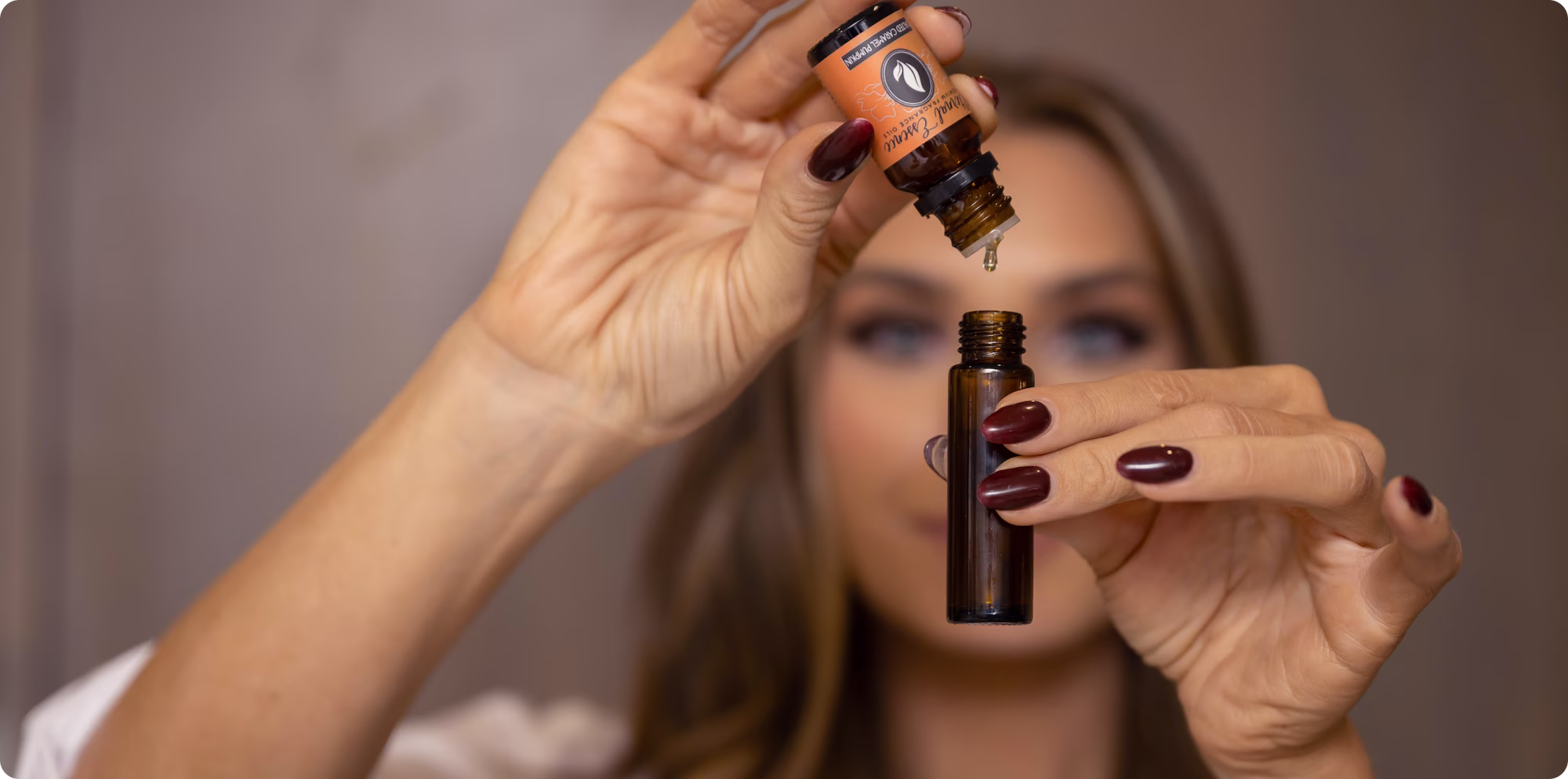 Hands hold brown glass dropper bottle.