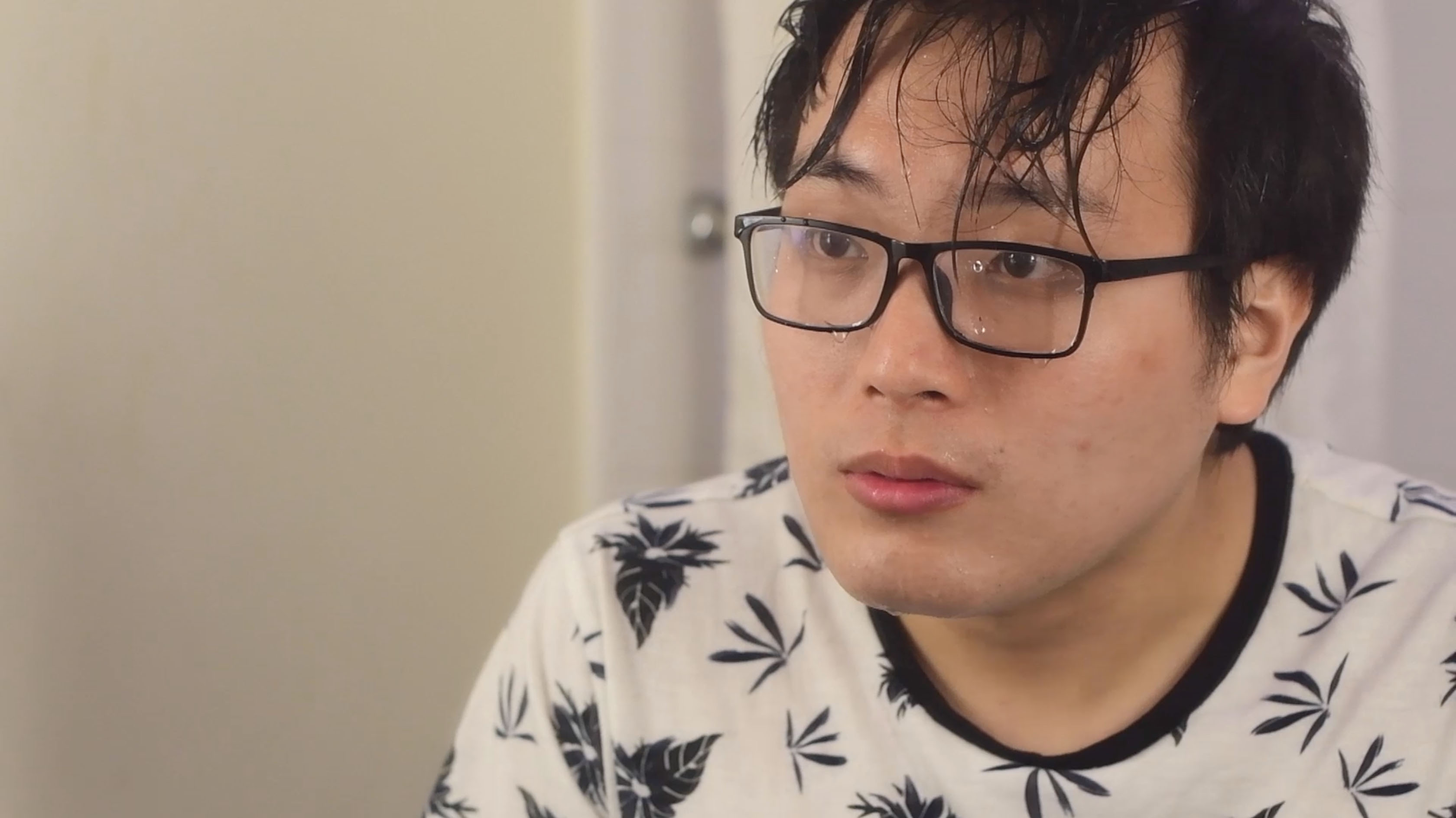 A man who has made his hair wet and downed himself in water, he is looking into the mirror