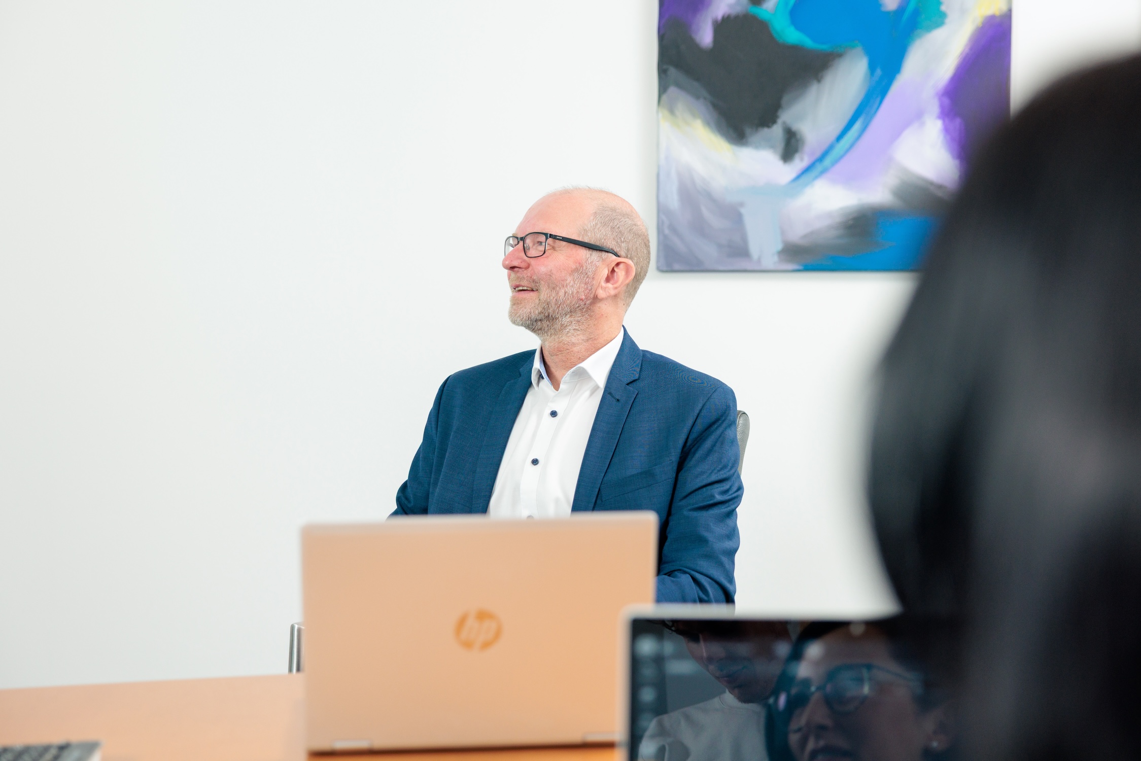 Steuerberater am Laptop im Gespräch mit einer Kollegin