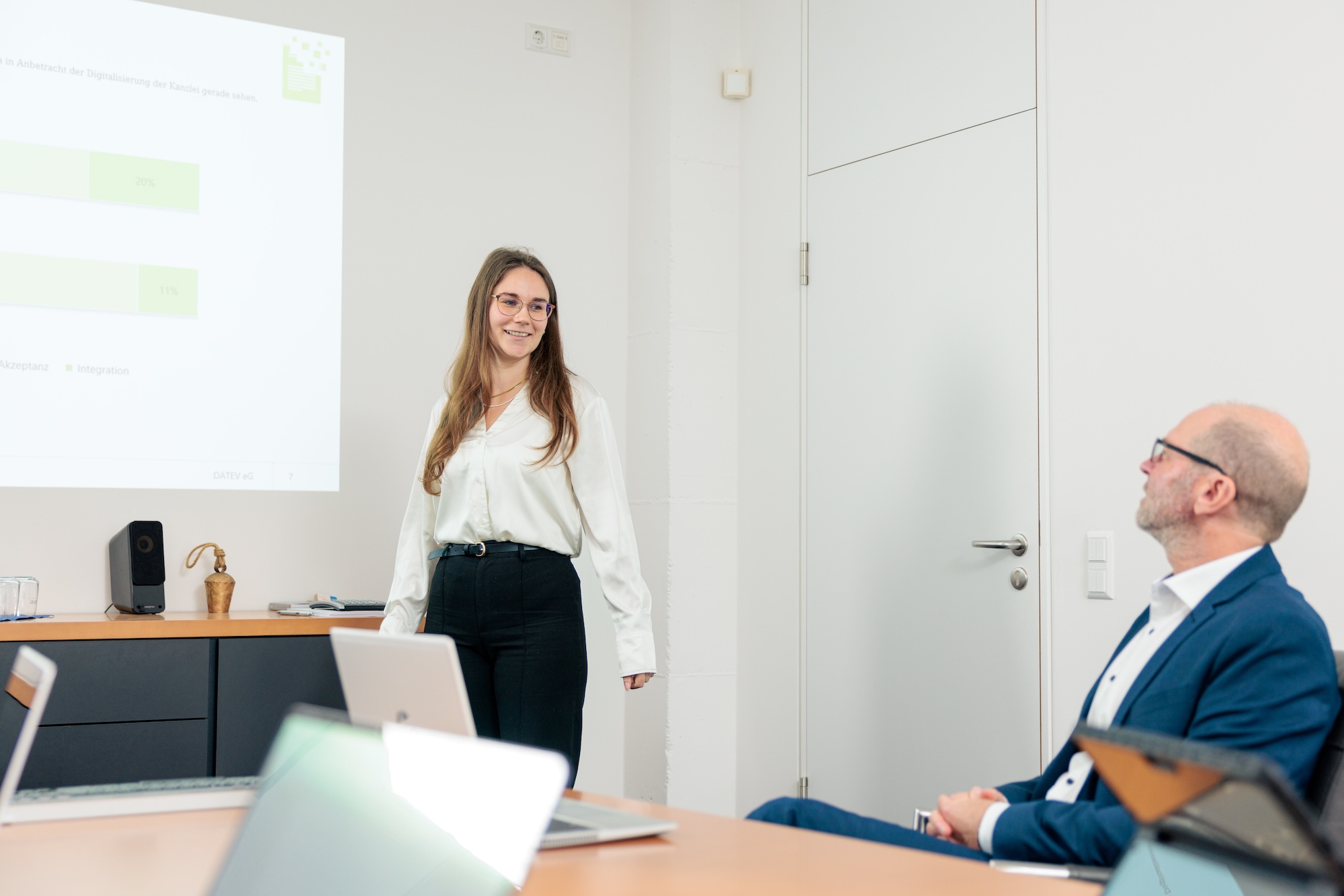 Mitarbeiterin hält eine Präsentation vor Kollegen im Besprechungsraum
