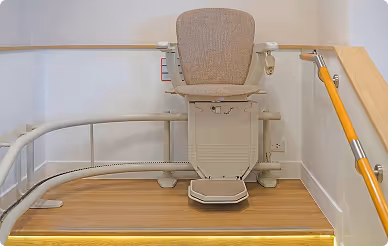 Stairlift installed at the top of a curved staircase for safe and independent home mobility.