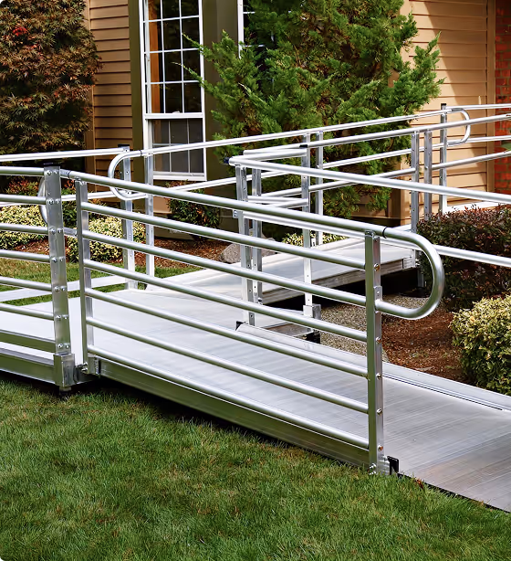 Modular aluminum wheelchair ramp installed at a home entrance to provide safe and accessible outdoor mobility.