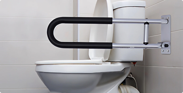 Toilet safety rail mounted beside a toilet to provide support and stability for safe bathroom use