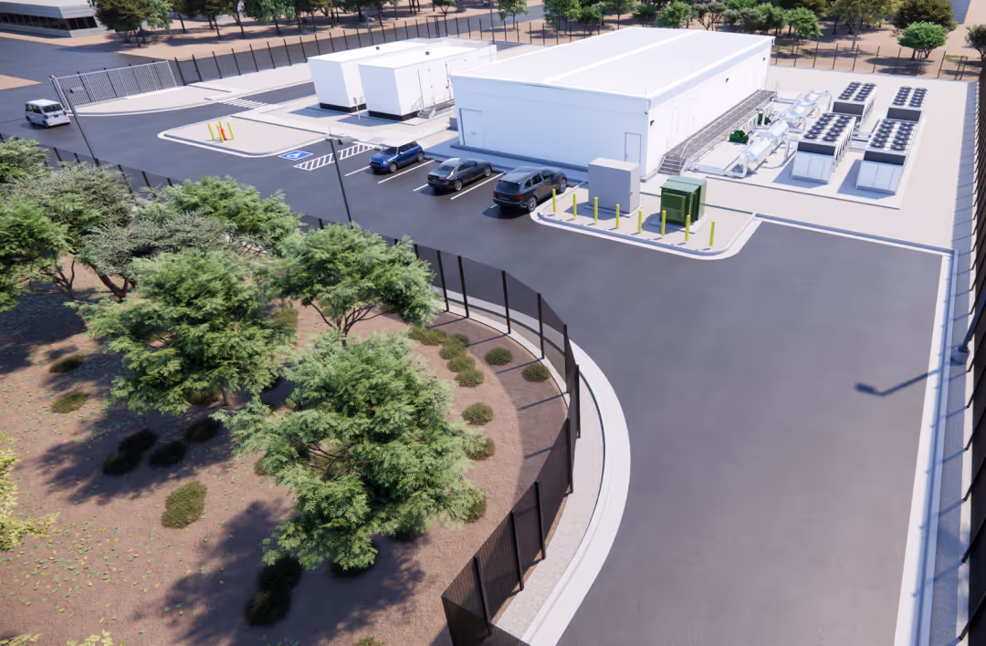 Render of a secured AI data center facility with modular buildings, cooling systems, parking spaces, and surrounding fencing in a desert environment.