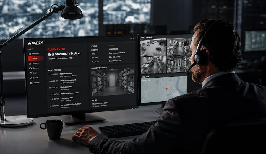 Monitoring operator reviewing a warehouse alarm event and security camera feeds