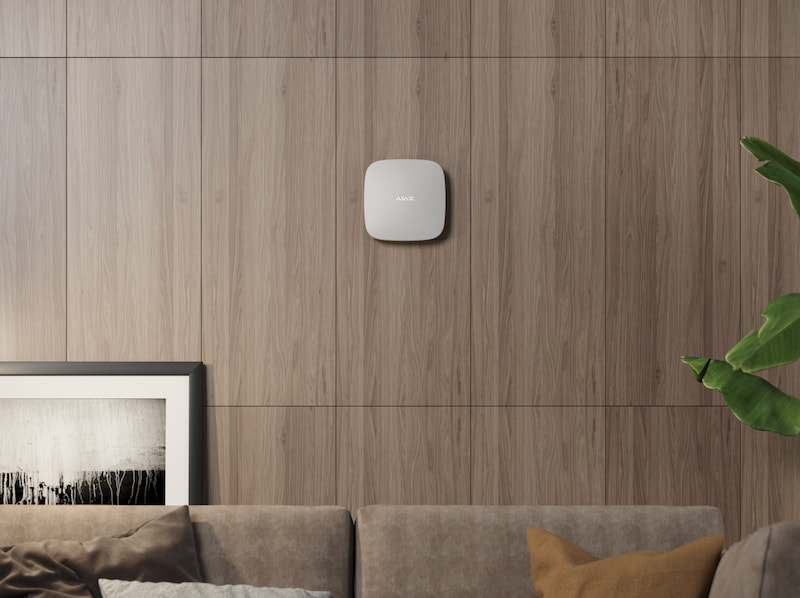White Ajax security hub mounted on a living room wall