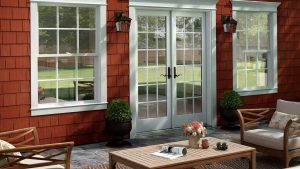 red colored vinyl shake siding on home with patio doors and windows