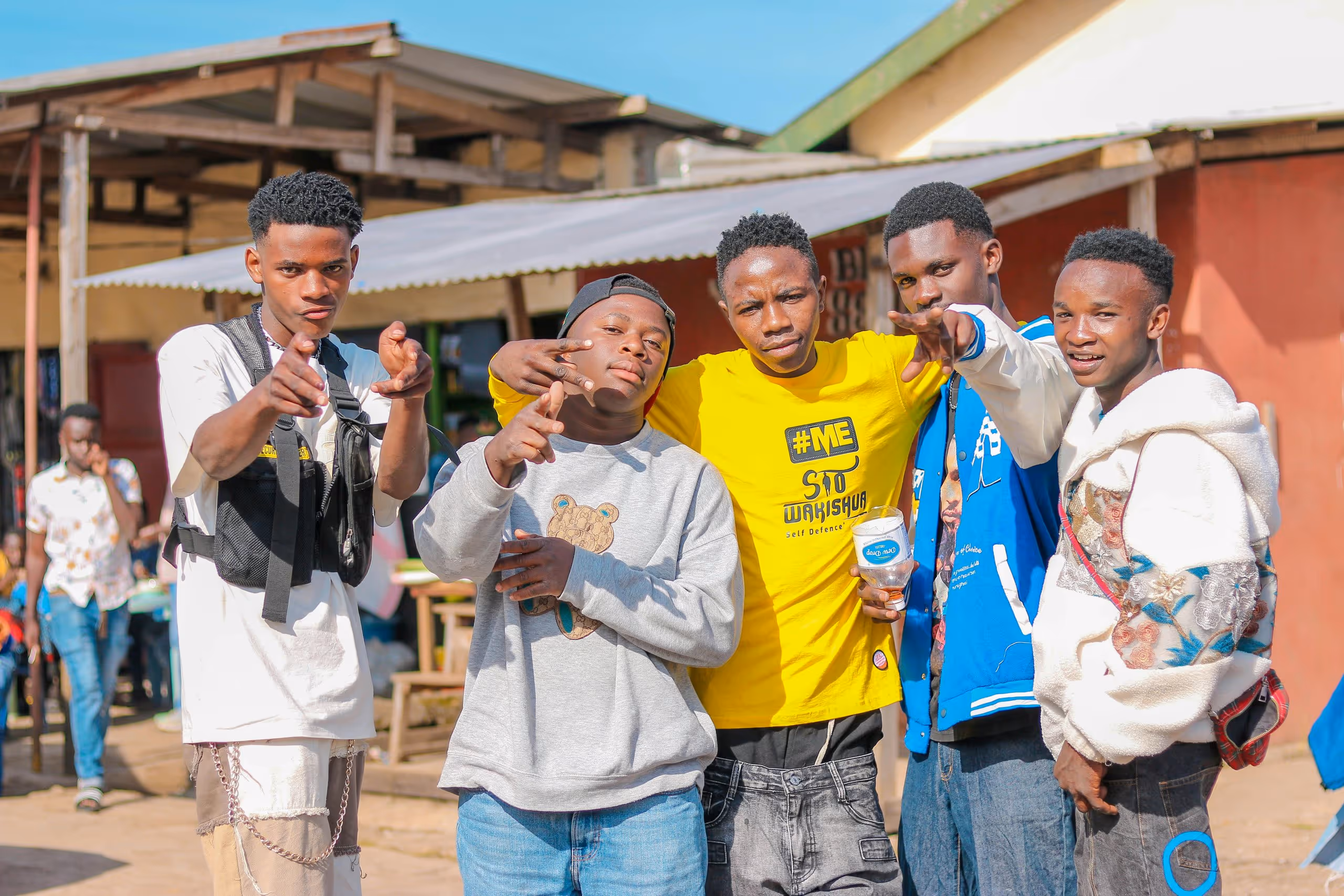 A group of teenagers pointing at the camera