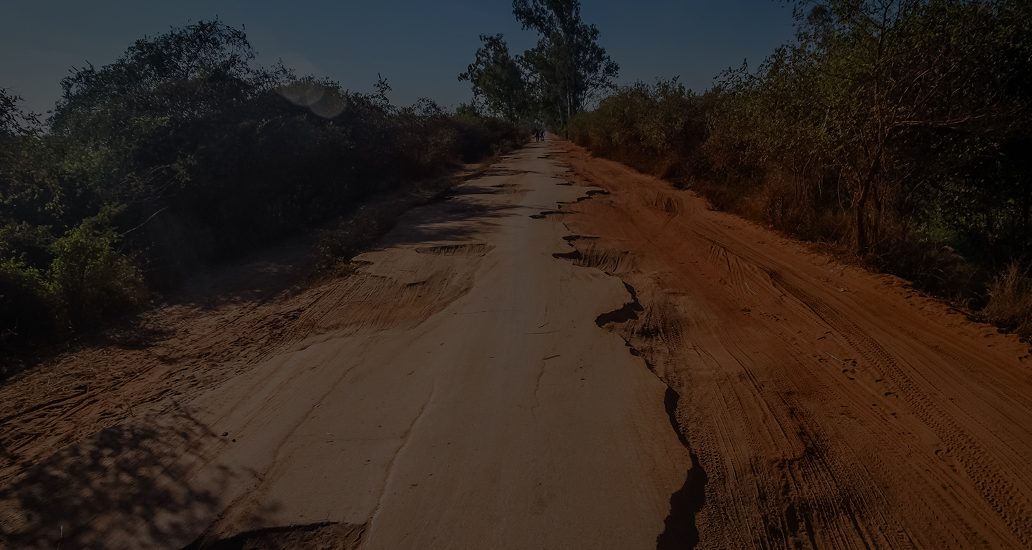 A rough red dirt road winding through the bush