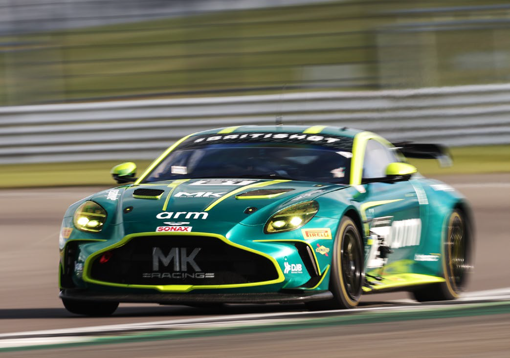 Green and yellow MK Racing car speeding on a race track with motion blur.