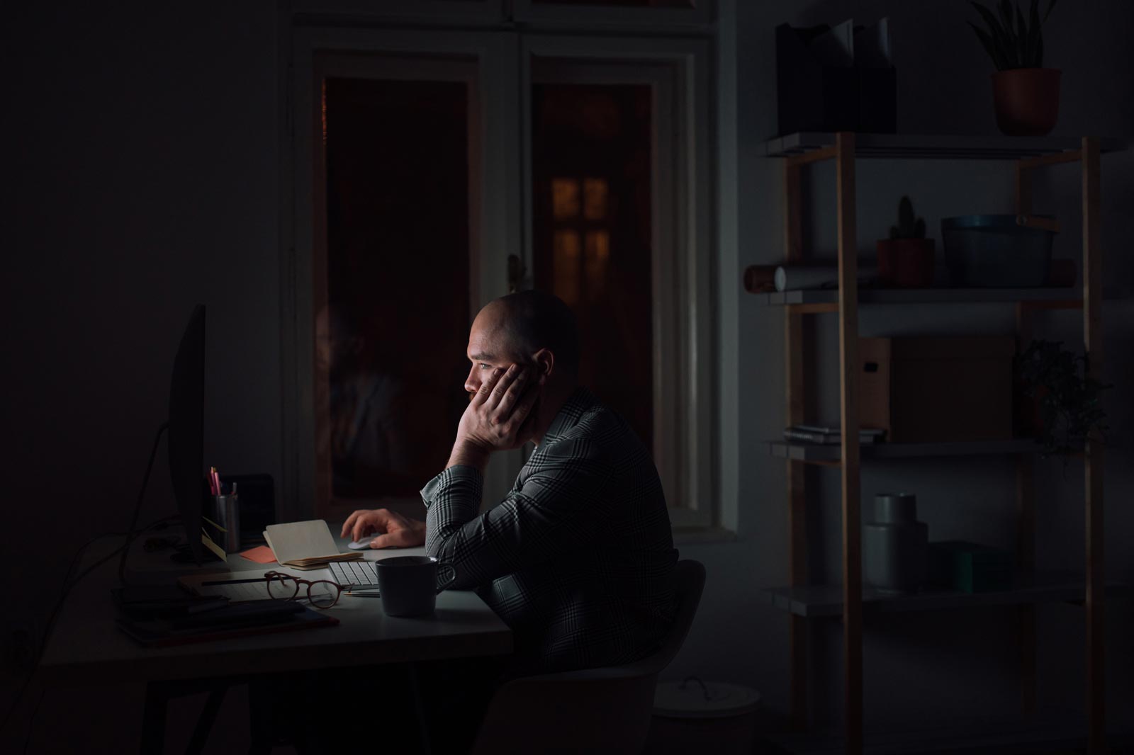 An image of a man sitting at a computer