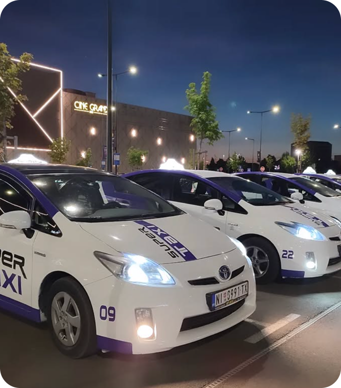 Open menu with a green page listing vitamin juices and prices in Serbian, next to a cartoon black fox wearing red boots holding a glass, on a wooden table with a person's hand nearby.