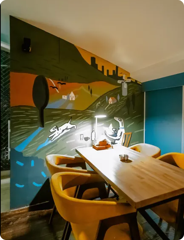 Person using a stylus to draw a digital illustration on a tablet with the word 'ANXIES' and abstract shapes.