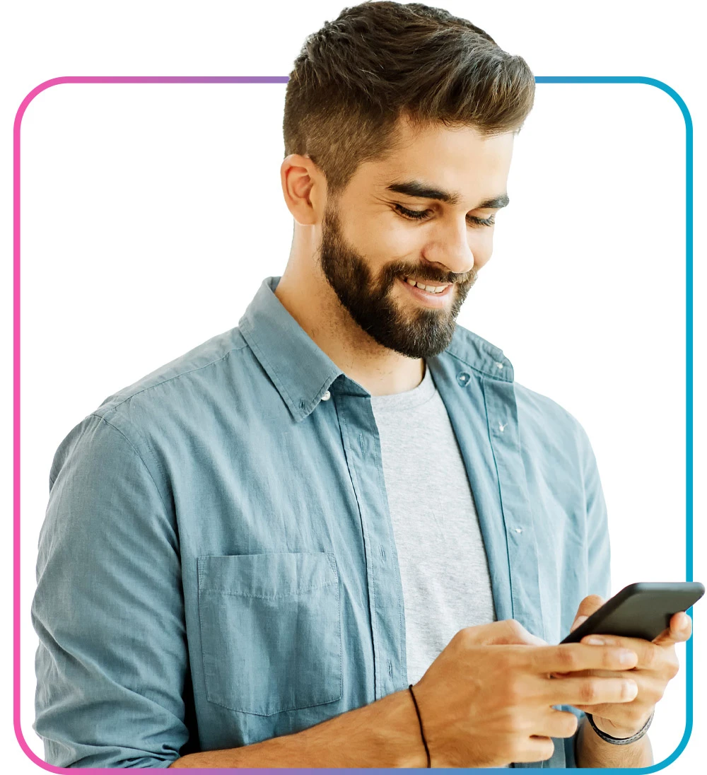 Bearded man looking down at phone and smiling