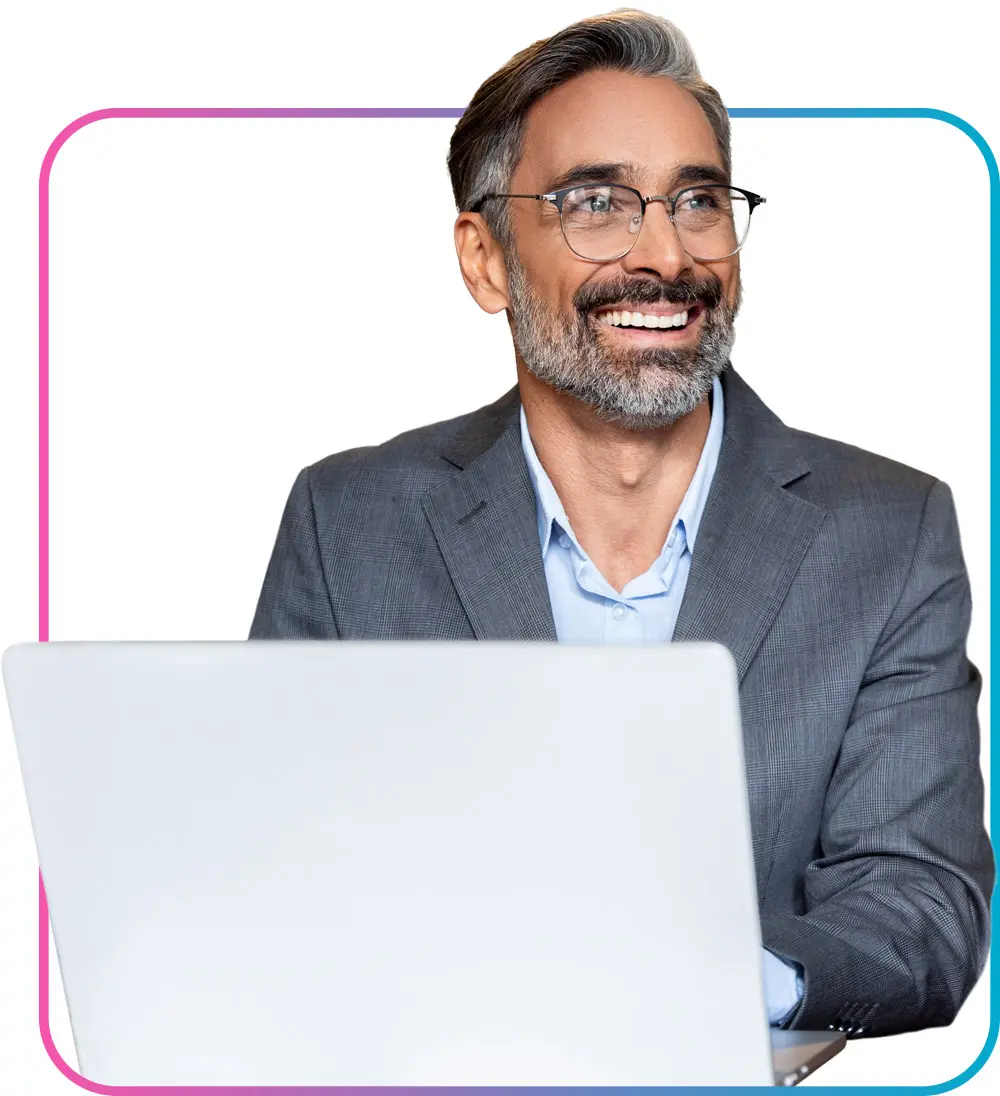 Business professional man typing on open laptop while smiling off to the side