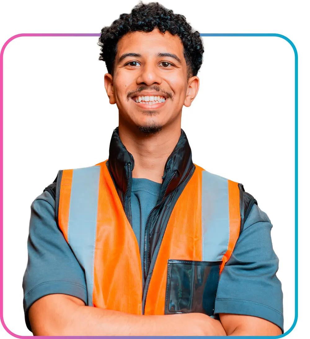 Man in orange safety vest crossing arms while smiling