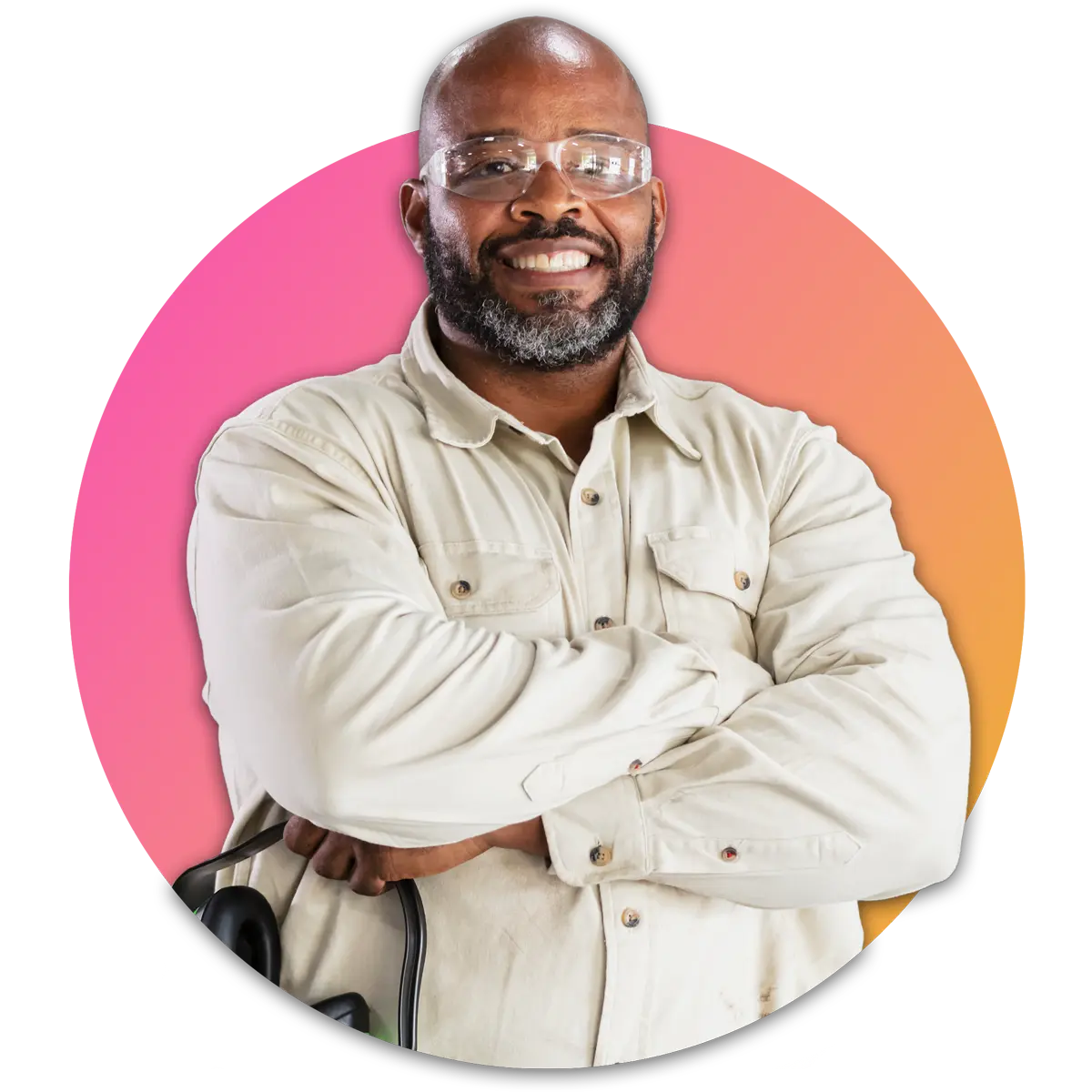 A man with safety glasses holding headphones crossing arms and smiling