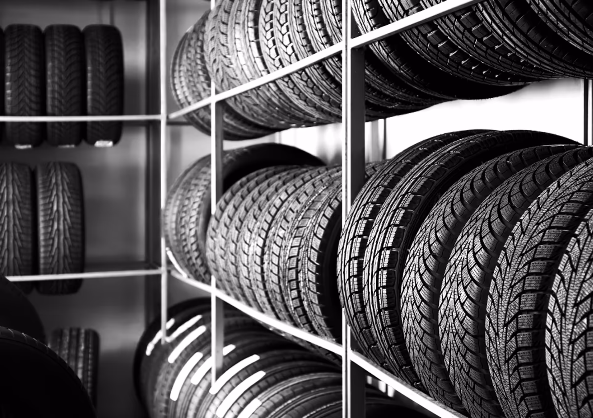 Reifenregale mit mehreren Reihen von Autoreifen in einem Lagerraum.