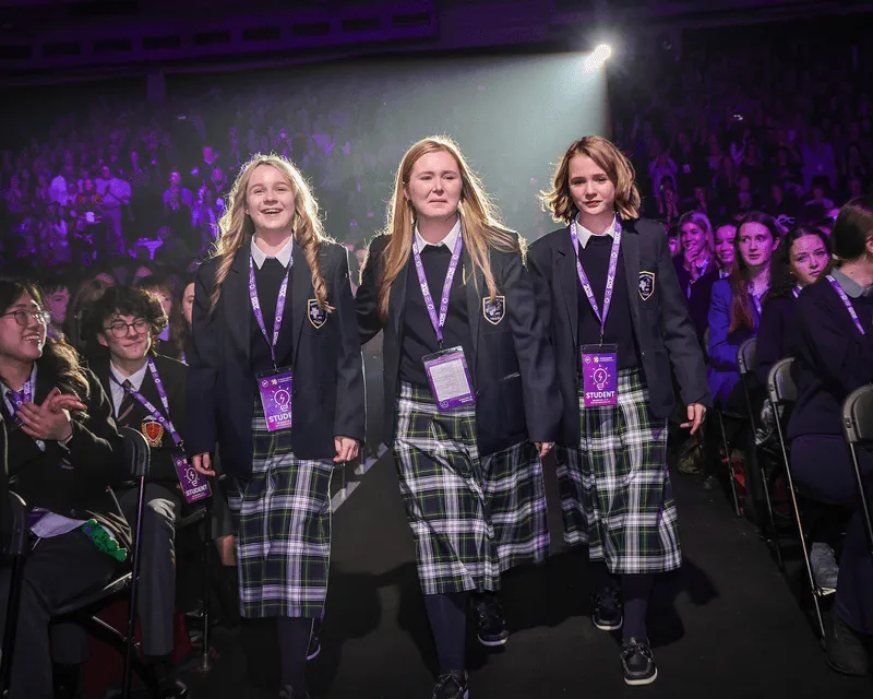 Three young women walking on stage to accept their award.