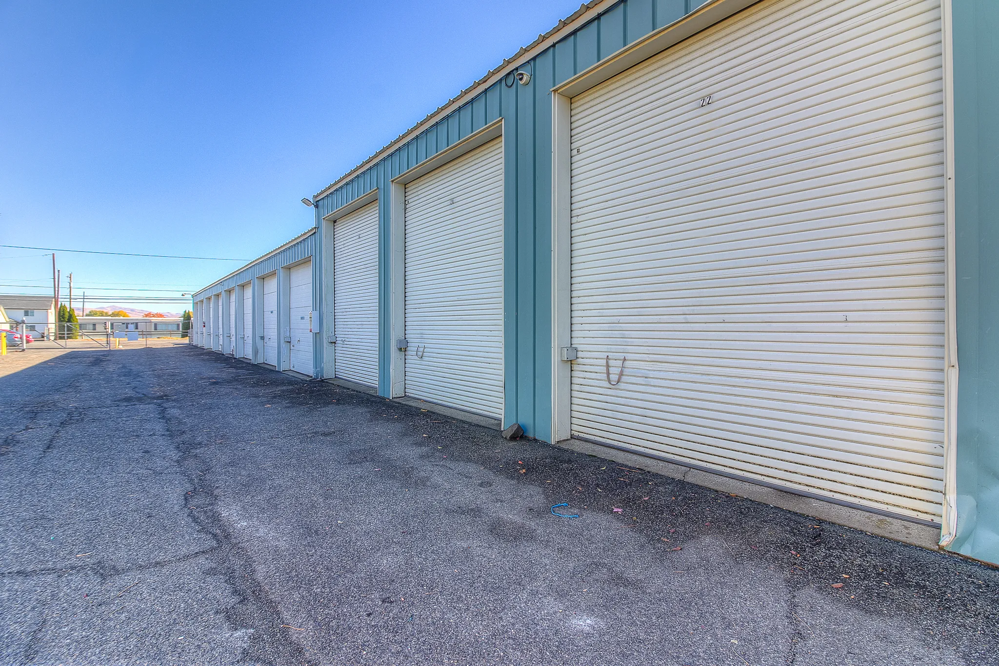 Paved drive between large secure storage units at Security 1st Storage, 34th Avenue, well-lit area with wide turning space and gated entry.