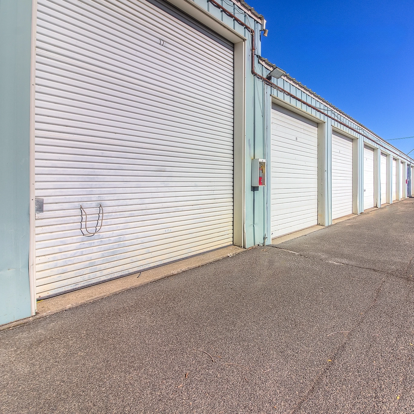 Row of white steel storage unit doors at West Yakima Storage on N 34th Ave, showing secure, clean, well-maintained drive-up access.