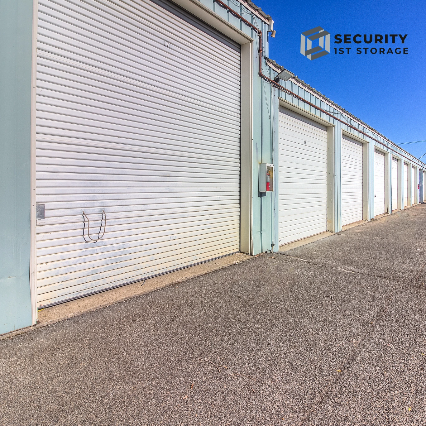 Row of white steel storage unit doors at Security 1st Storage, 34th Avenue, showing secure, clean, and well-maintained drive-up access.