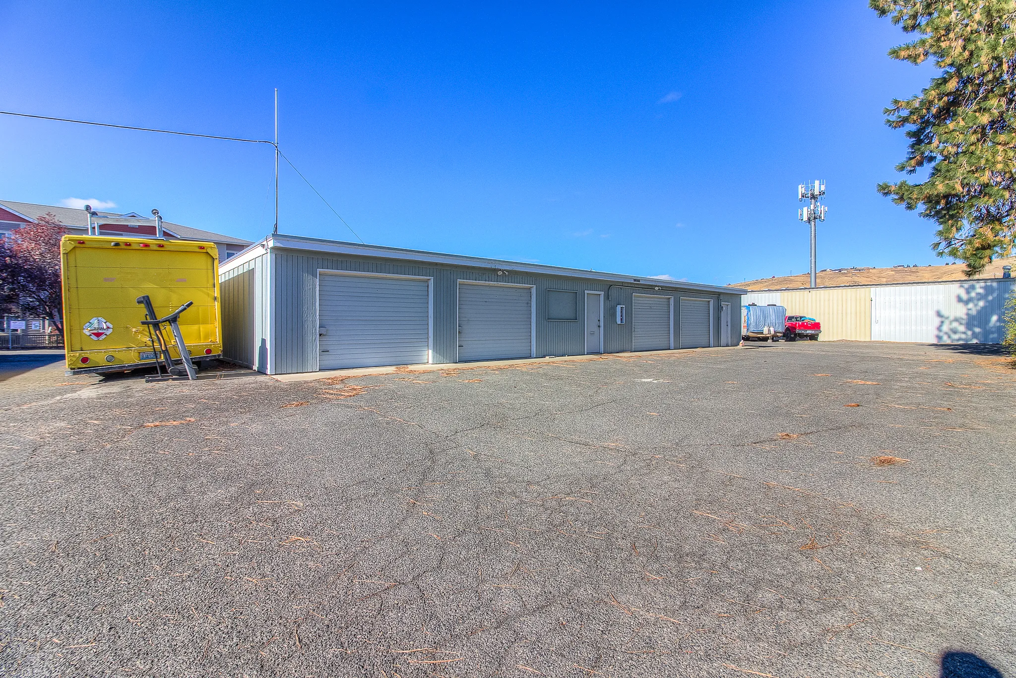 Wide paved lot at Security 1st Storage, 34th Avenue, with garage-style storage units, fenced security, and vehicle parking access.