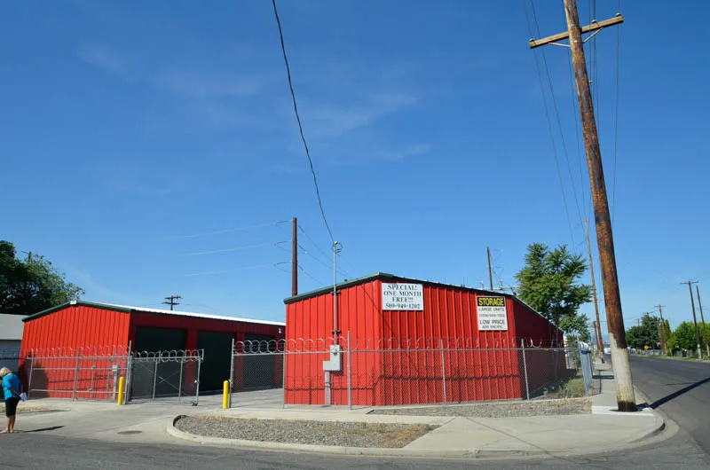 Corner view of Security 1st Storage on Pacific Avenue, fully fenced compound with gated entry and security signage.