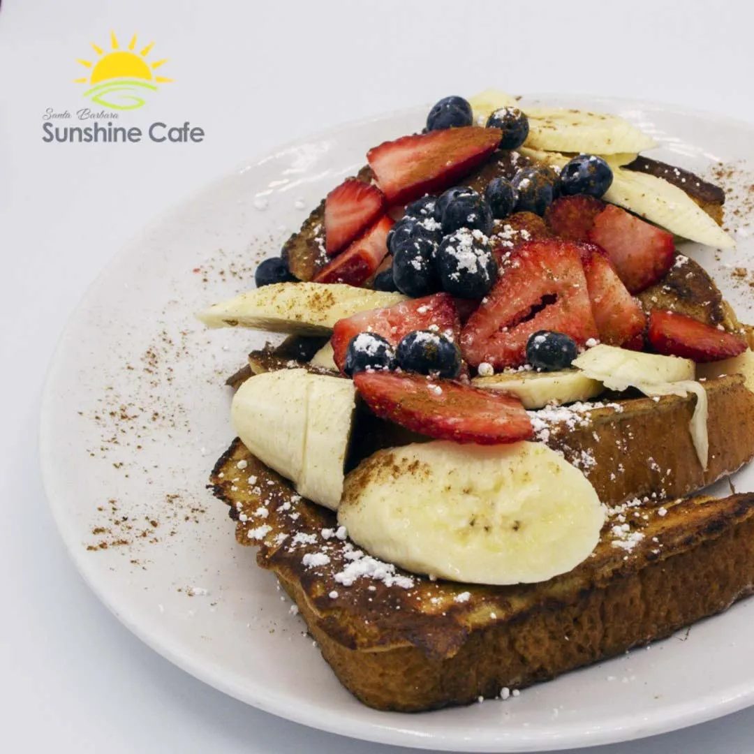 French Toast with maple syrup, strawberries, blueberries, and bananas