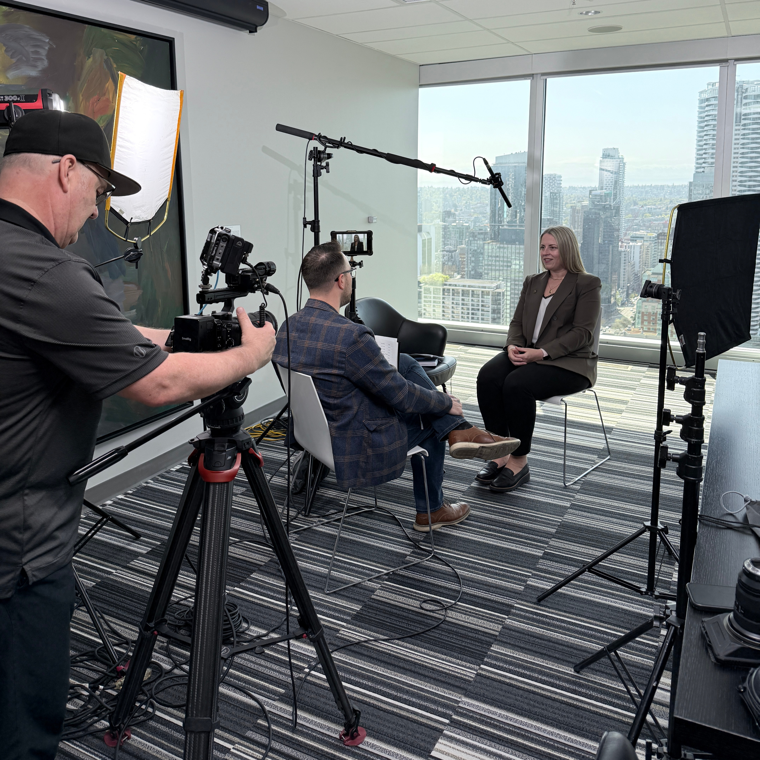 Double H Creative production crew filming an executive interview against a Vancouver skyline backdrop